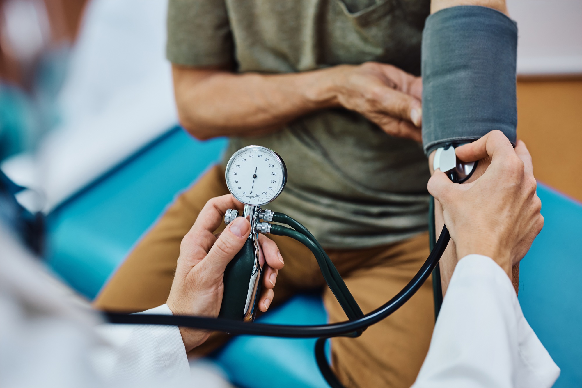 how often do doctors visit nursing homes - Close up of doctor measuring blood pressure of an elderly patient.