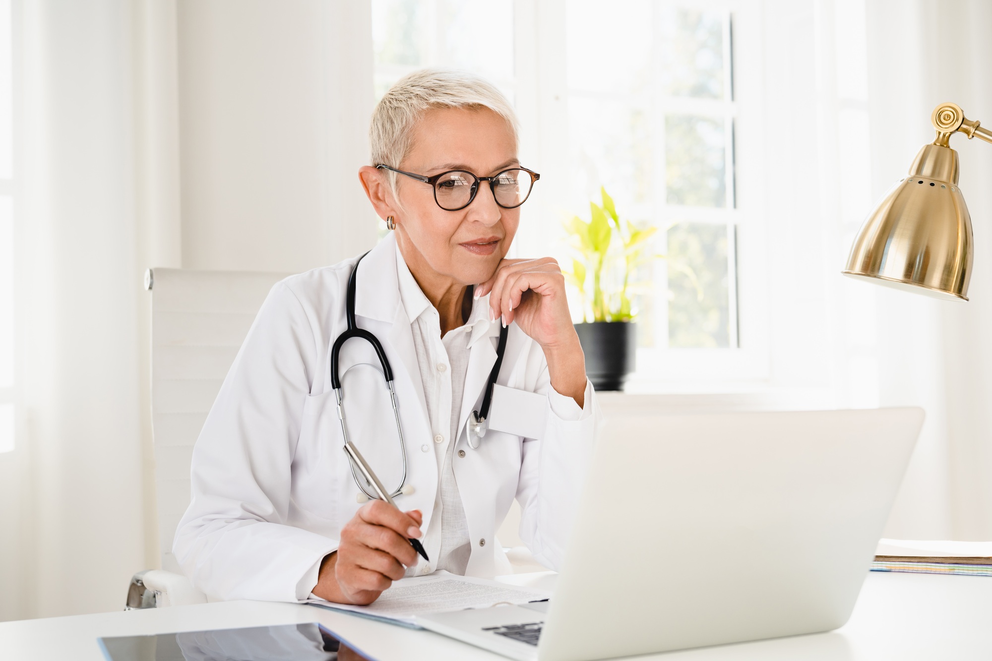 A telehealth doctor conducting a virtual consultation with a patient on a laptop, discussing symptoms and treatment options for an acute medical conditions.